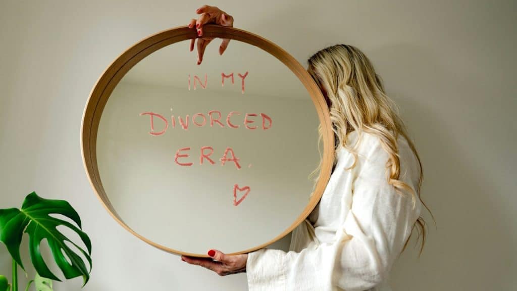 Woman holding mirror with text in my divorced era.