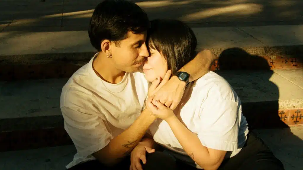 A couple hugging each other while sitting on the stairs.