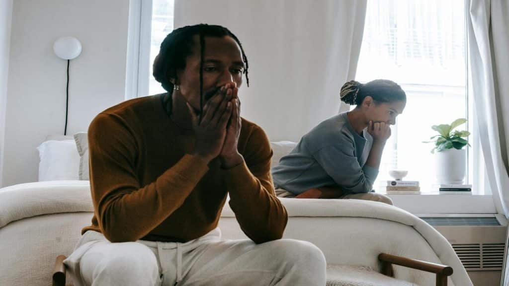 A couple looking sad in bed