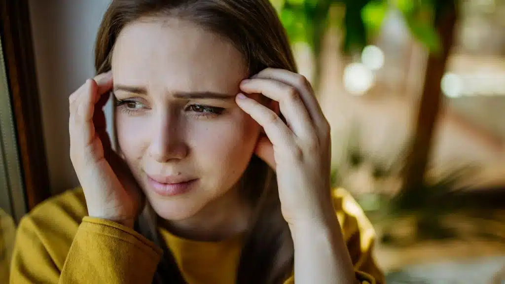 A woman suffering from depression crying at home.