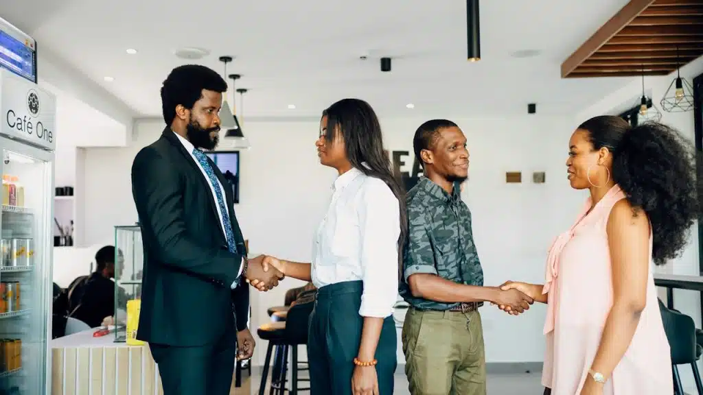 People shaking hands with each other in an office.