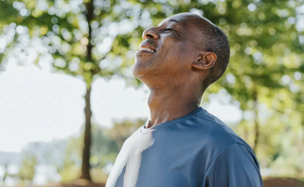A man taking a deep breath outdoors