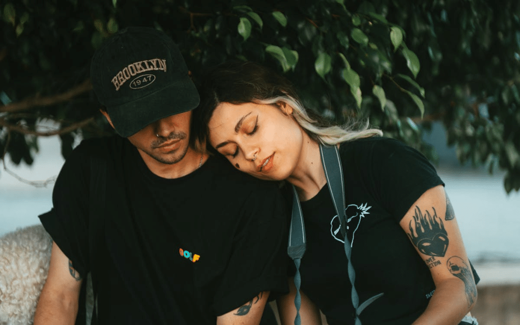 Couple resting under leafy tree