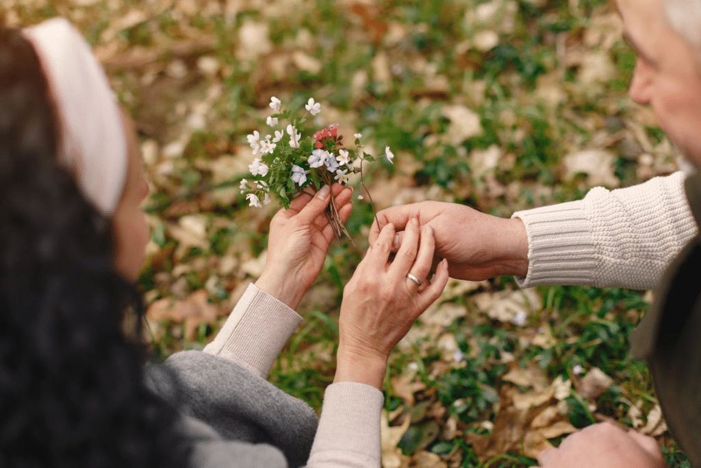 Senior couple holding flowers in park