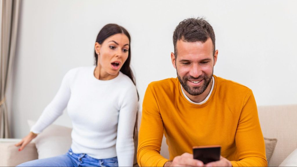 A woman seeing something suspicious from man’s phone
