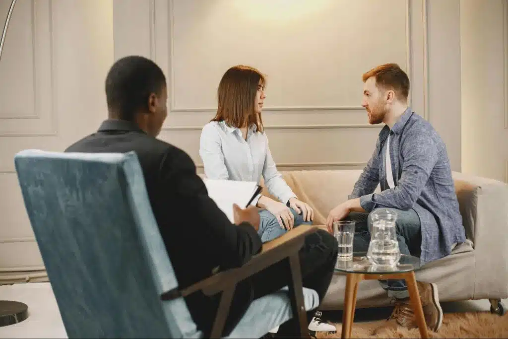 A man and woman talking in front of a counselor