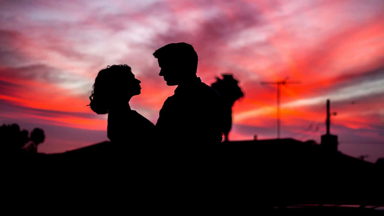 A couple looking at each other at dusk