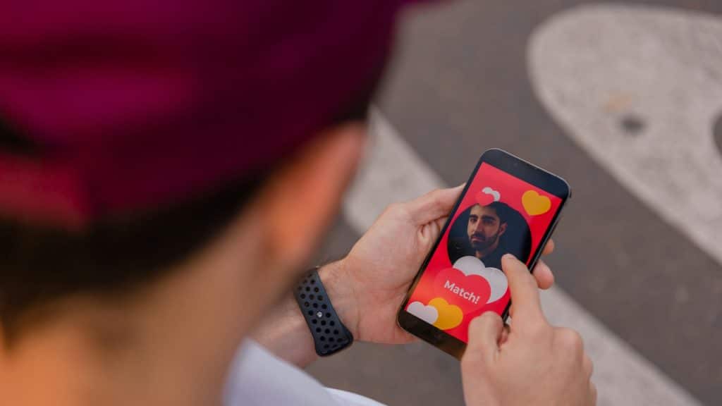 A person holding a cell phone with a profile of a man on it.