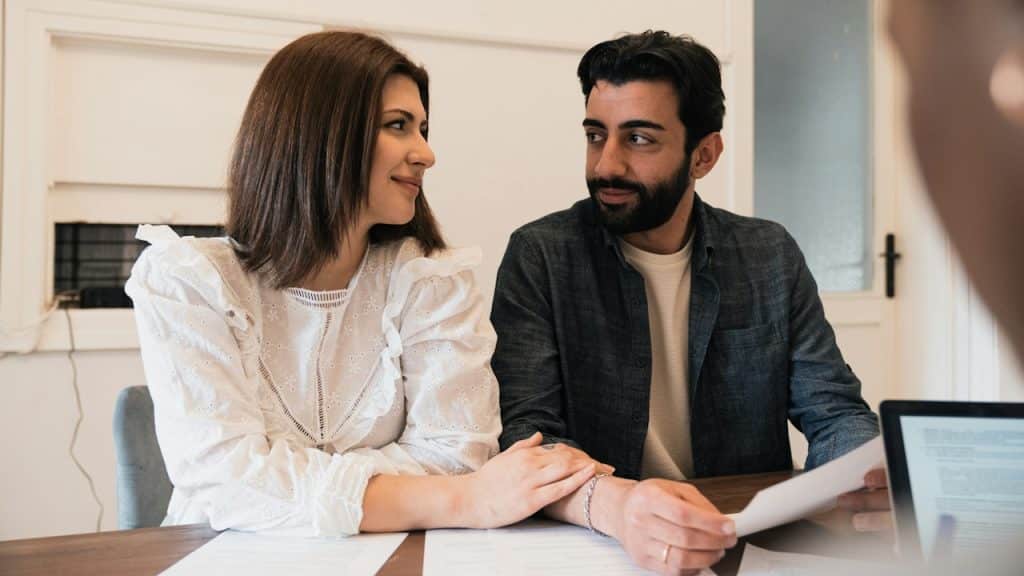 A man and a woman are looking at each other while sitting at a table.