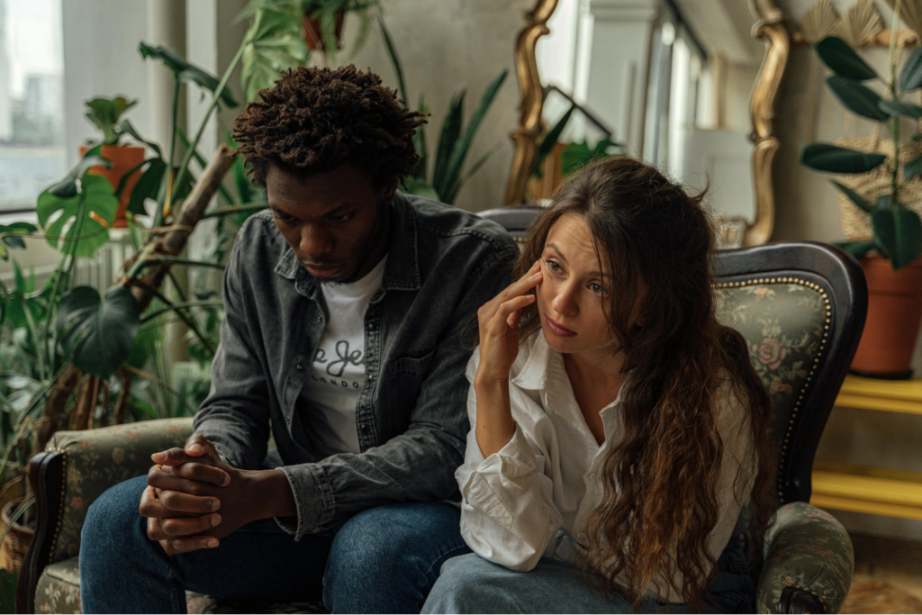 Unhappy Couple Sitting Next to Each Other on a Couch
