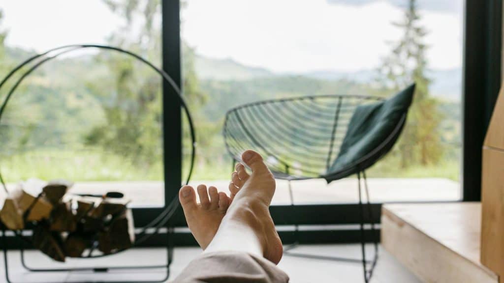 A person relaxing indoors with a scenic view outside.