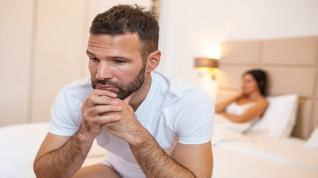 A couple looking sad in bed