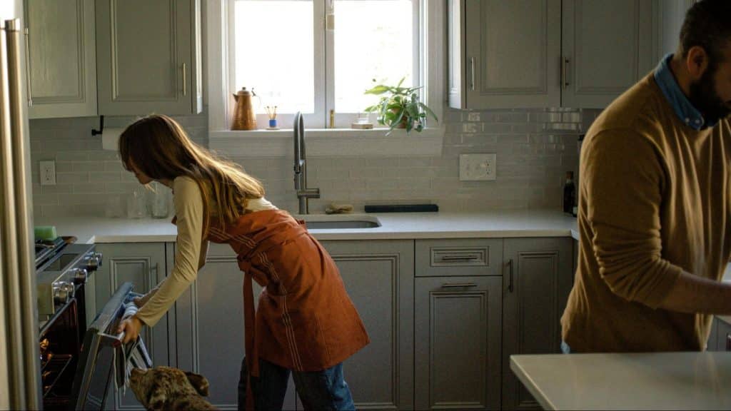 A man and woman at the kitchen but not talking to each other