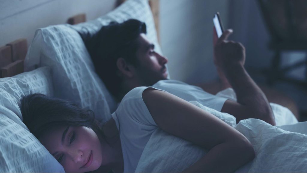 A man and woman busy with their phone