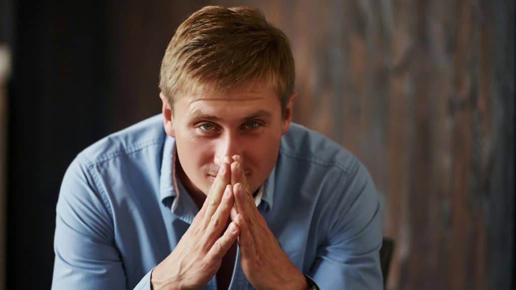 A man in a plain blue shirt, posing for a picture.