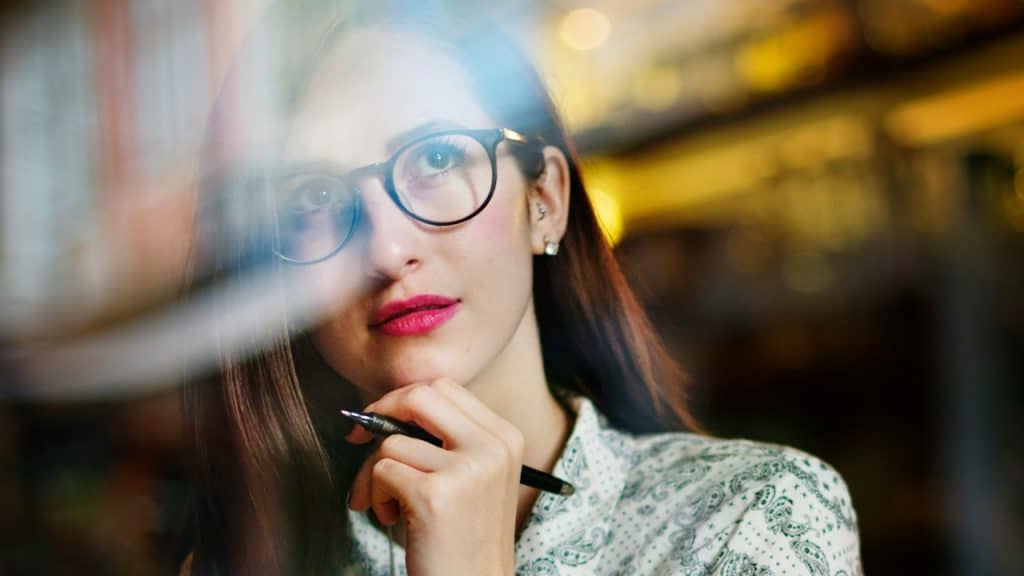 A woman holding a pen is writing something.