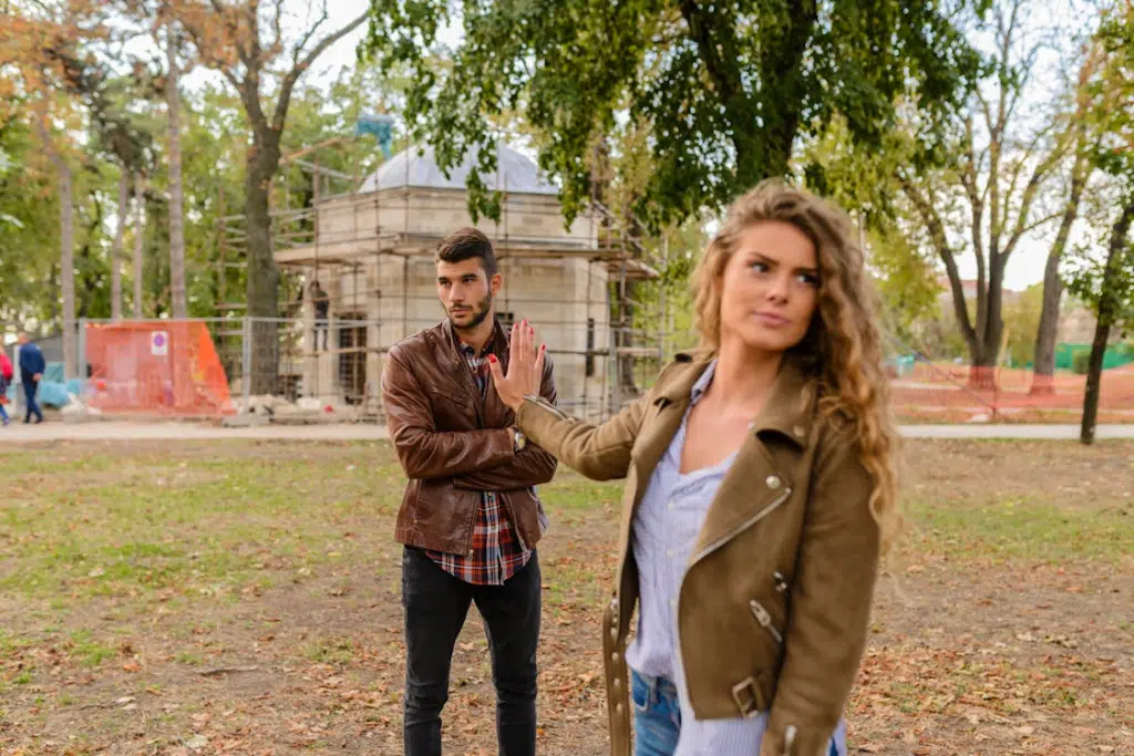 Woman shrugging off man outdoors