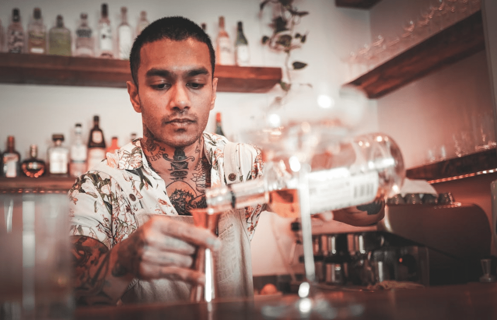 Man pouring drink at bar