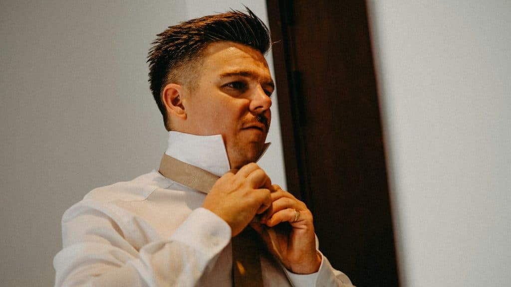 A man adjusting his tie while getting ready for his office.