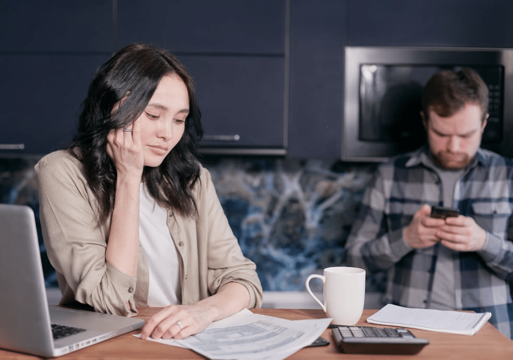Avoidant man looking at phone from upset wife