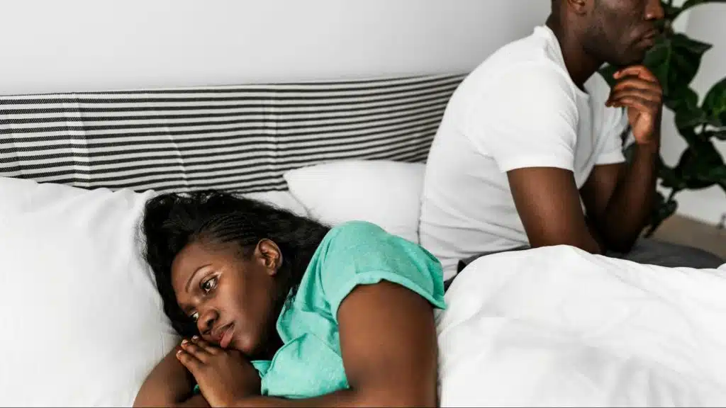 A man and woman at the bedroom but not talking to each other
