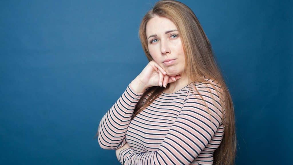 A woman with her hand on her chin.
