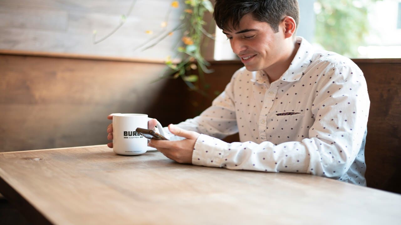A man smiling while texting