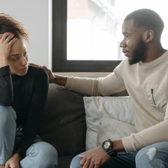 A man and woman sitting at the sofa