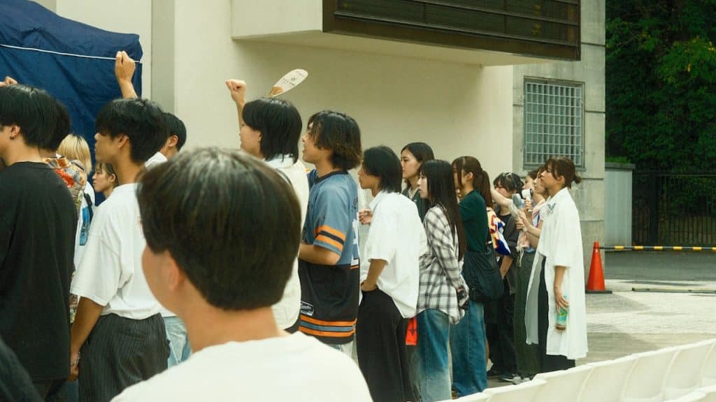 A diverse group of people standing in a line outdoors.