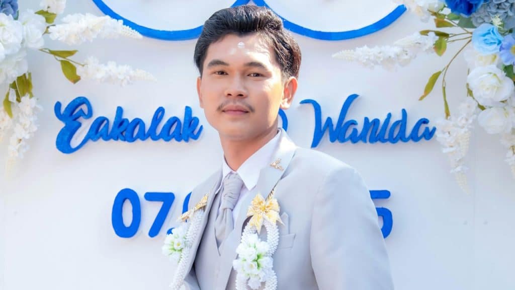 A man standing in front of a decorated wall.