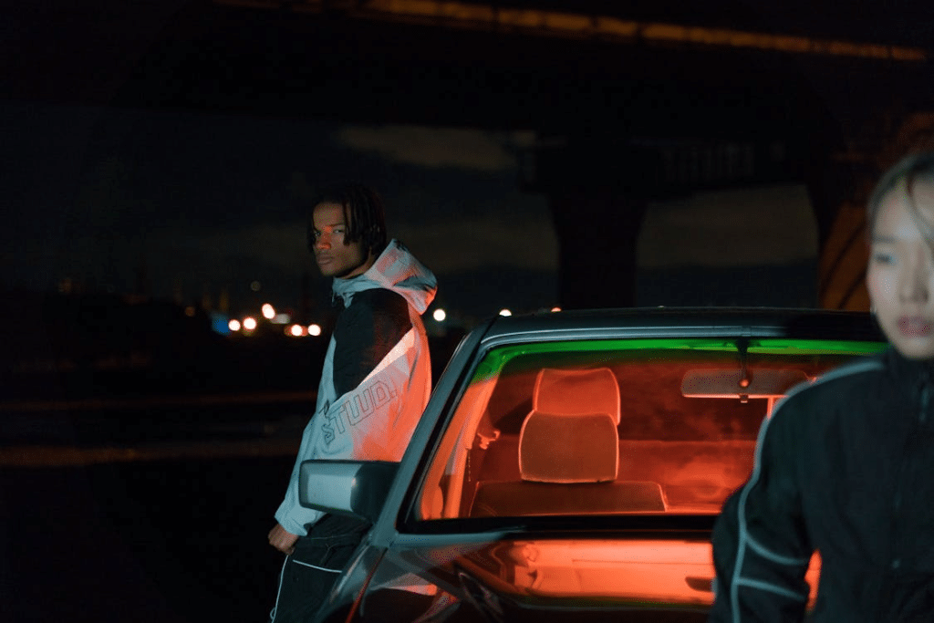 Unhappy couple leaning on car at night