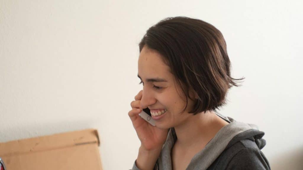 A smiling woman talking on the phone.