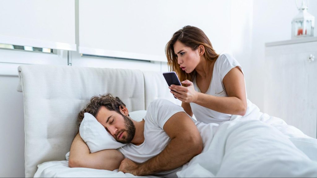 Woman checking man’s phone