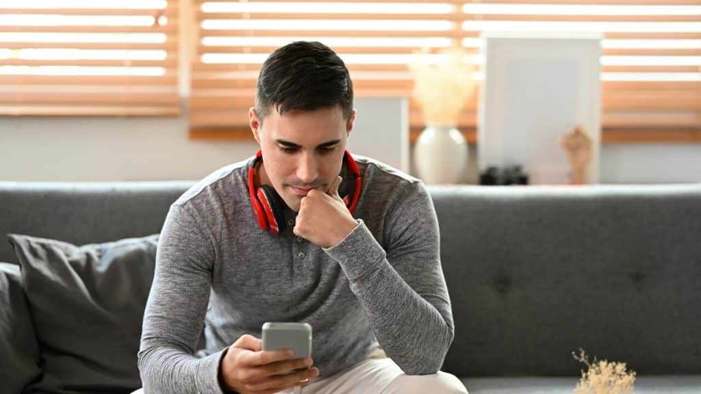A man looking somber while texting
