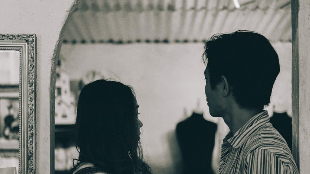 A man and a woman standing in grayscale photography.