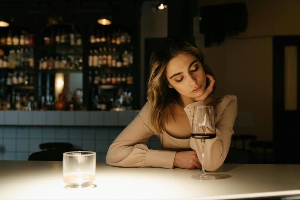 Woman thinking while drinking alone