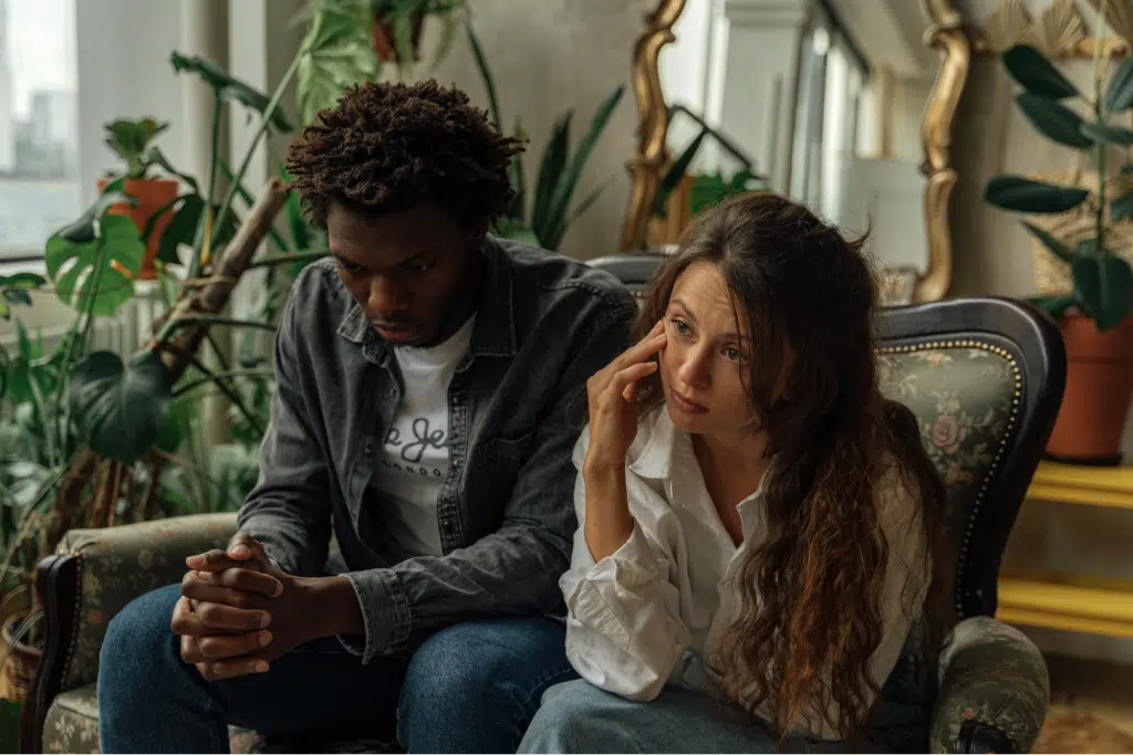 Unhappy Couple Sitting Next to Each Other on a Couch