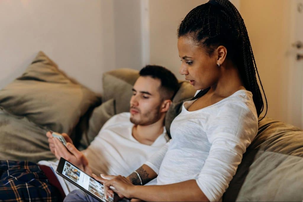 A man and woman busy with their gadgets