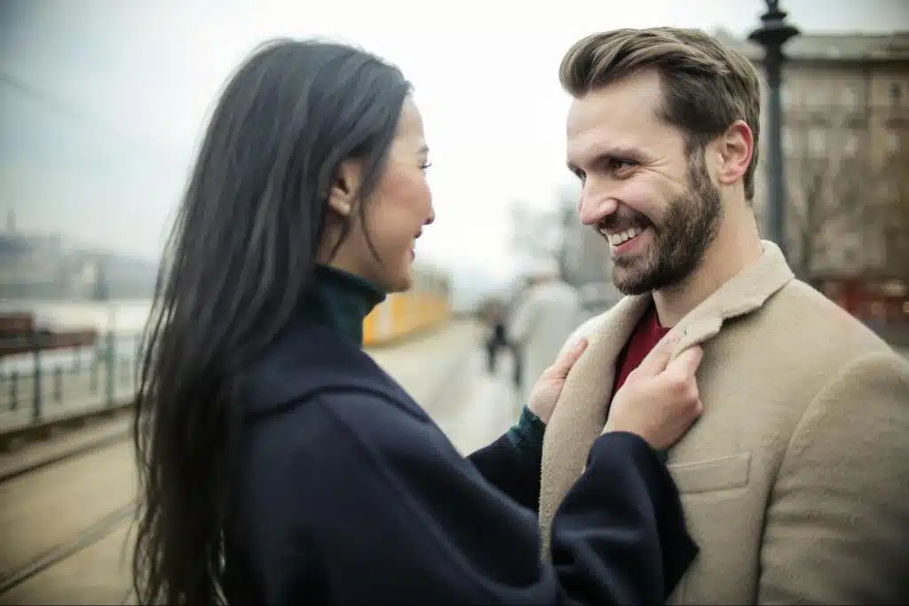 A woman holding man’s collar