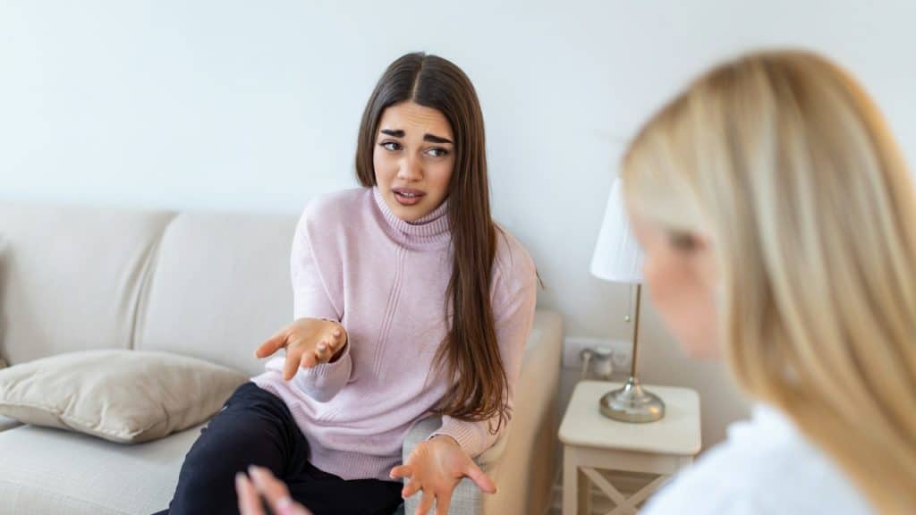 A sad woman is talking to a therapist.