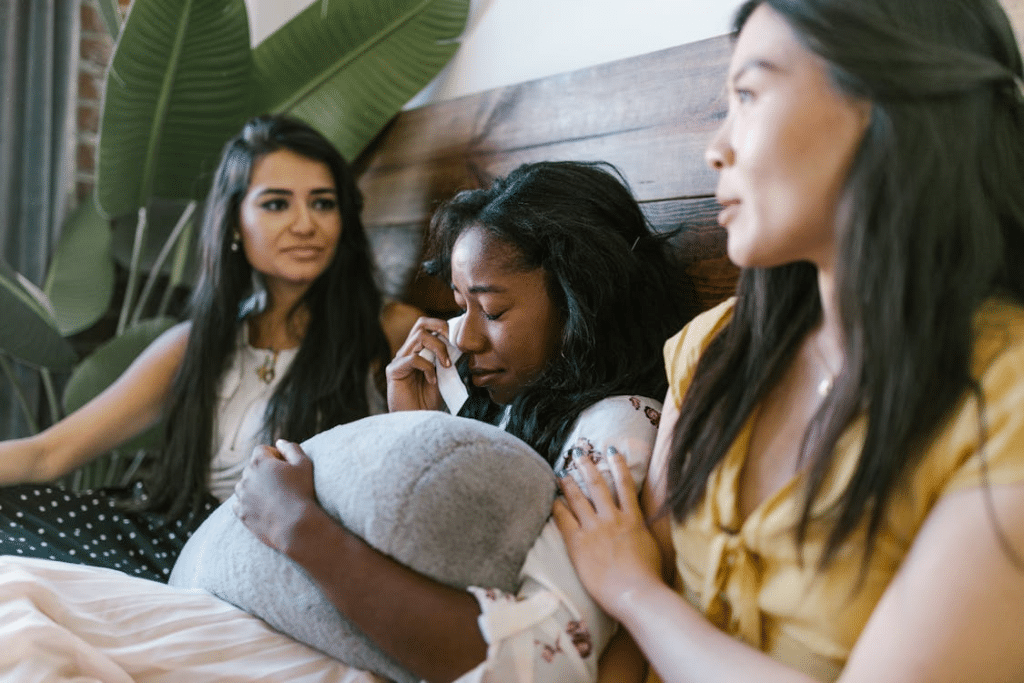 Friends Sitting on the Bed Consoling Crying Friend