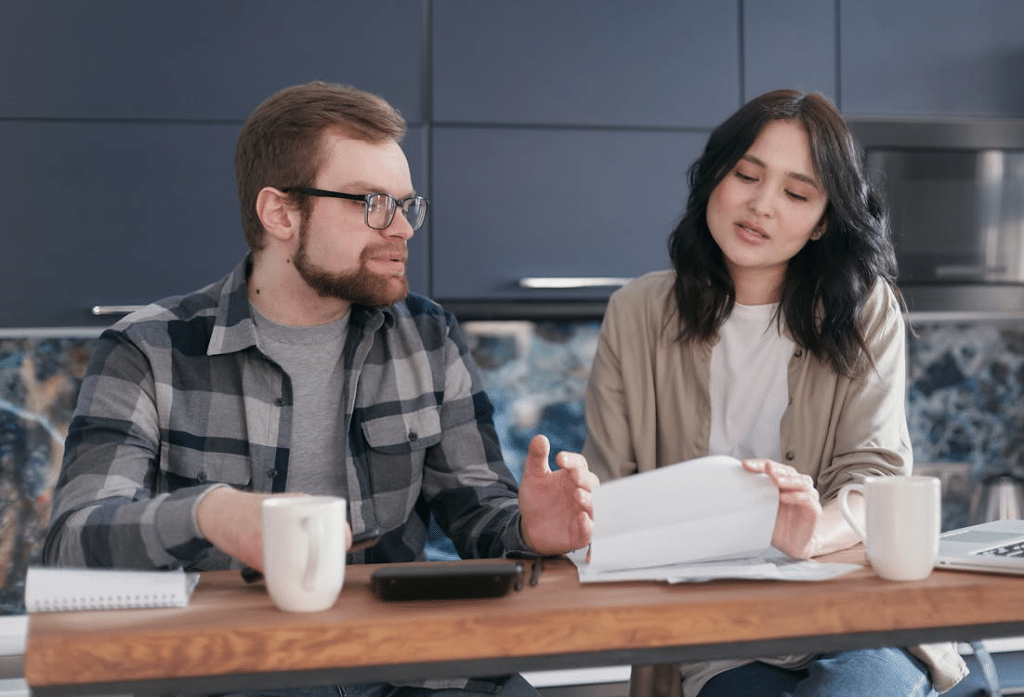 A Couple Sitting Near the Wooden Table while Having Conversation