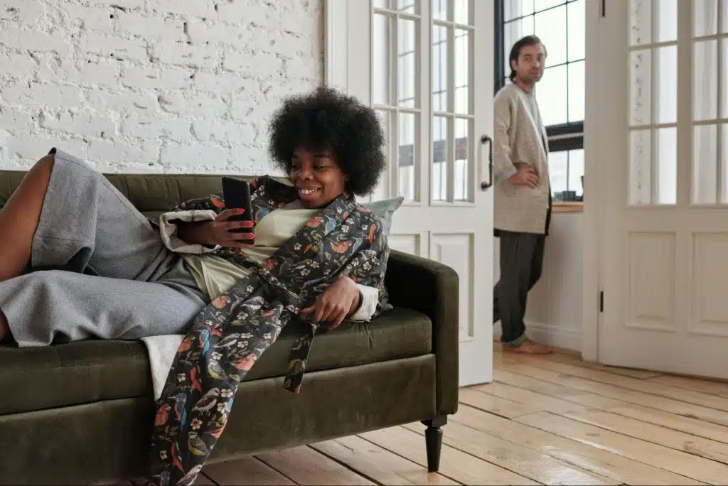 A woman lying on the sofa and texting someone