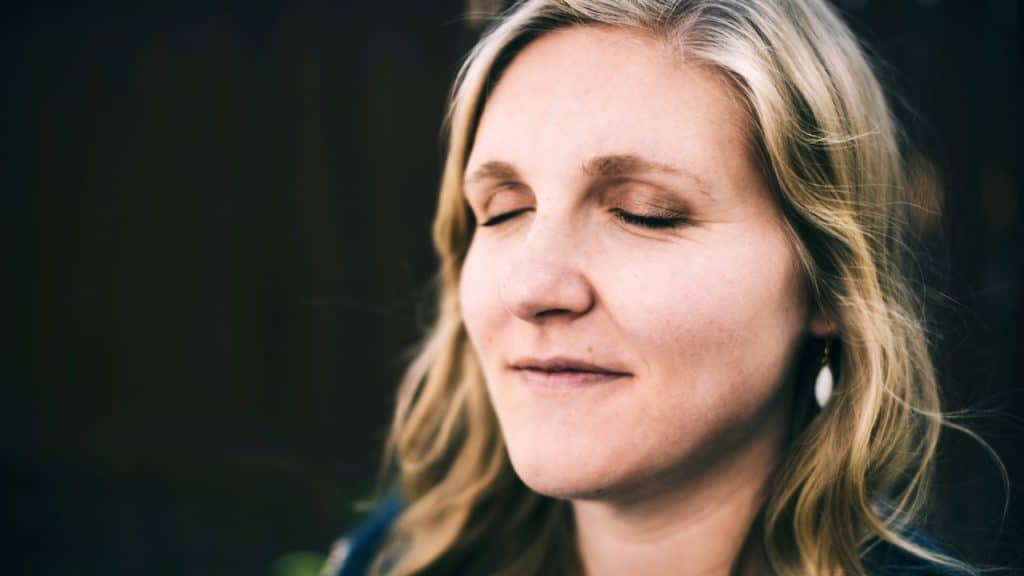 A mature woman with her eyes closed.