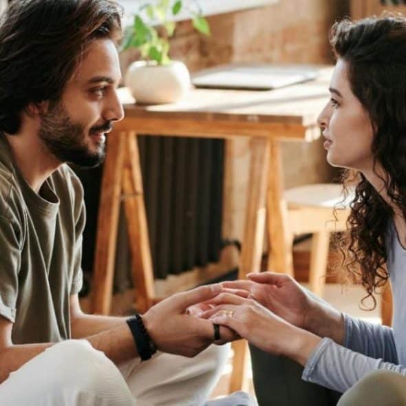 A couple holding hands while talking