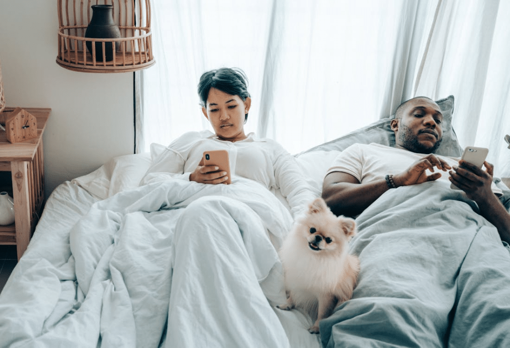 Couple in bed using phones