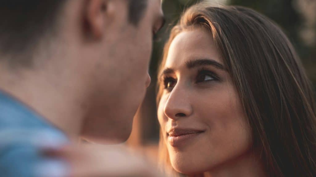 A woman gazing into a man’s eyes and smiling.