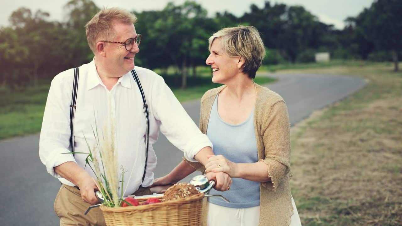 A man and woman walking with their bicycle