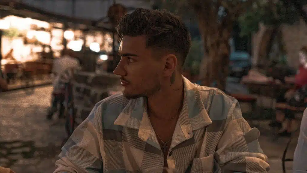Side view of a man sitting alone in an outdoor cafe.