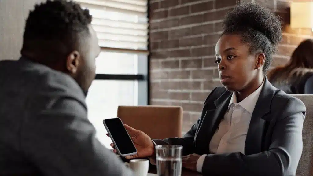 A rude woman showing something on her phone to her boyfriend.